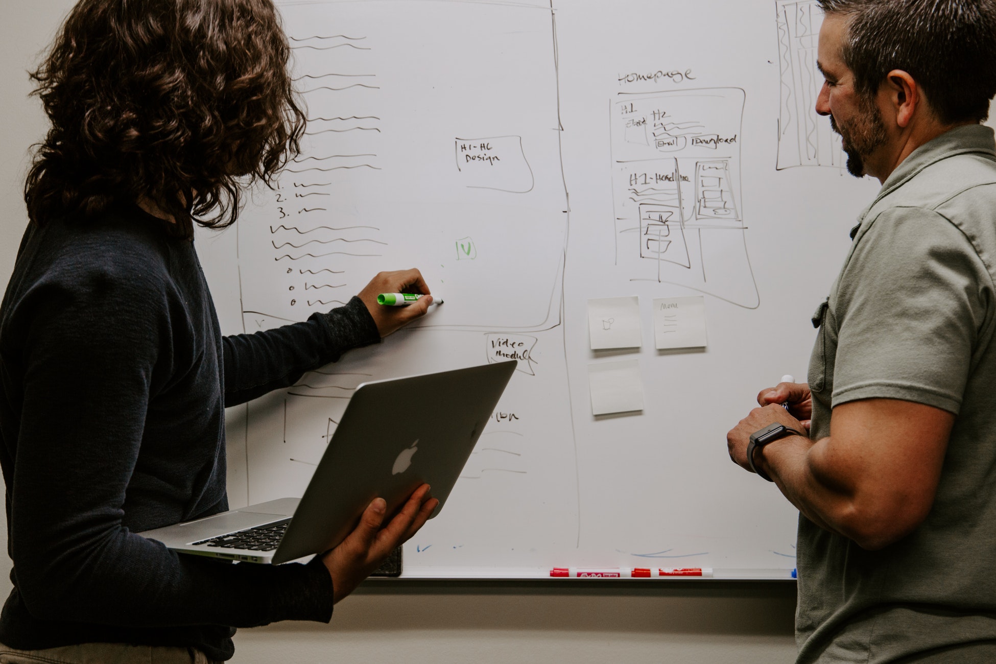 photograph of 2 people working on a blackboard